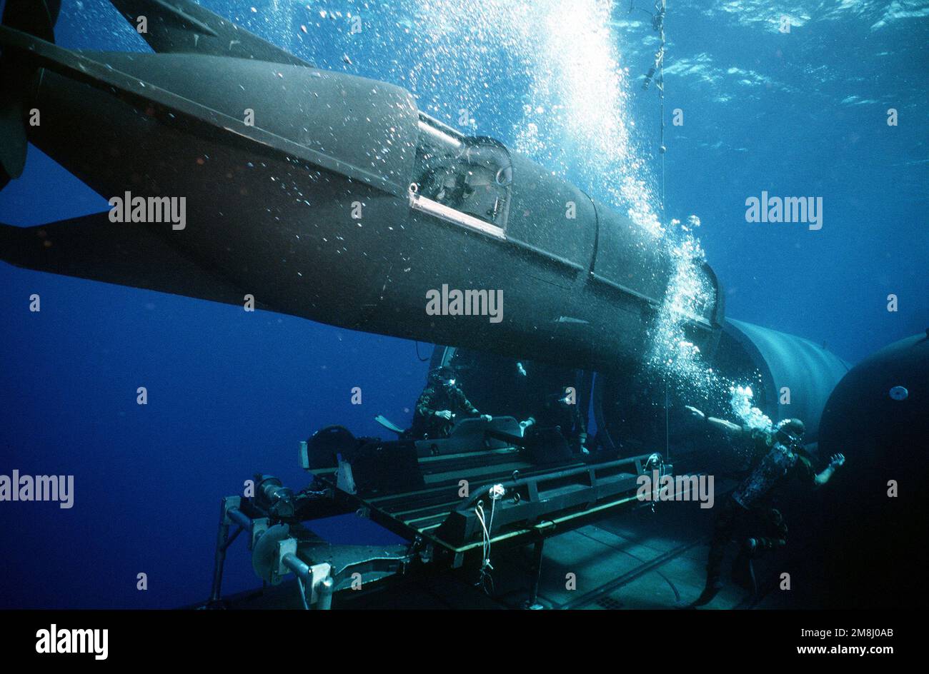 Ocean cross swell sposta il veicolo speciale per immersioni (SDV) sul lato mentre l'equipaggio DDS (Drydock Shelter) si prepara a legare la SDV sulla culla a bordo del sottomarino nucleare USS KAMEHAMEHA (SSN-642) durante le operazioni di duello shelter al largo della costa di Oahu, Hawaii. Paese: Oceano Pacifico (POC) Foto Stock