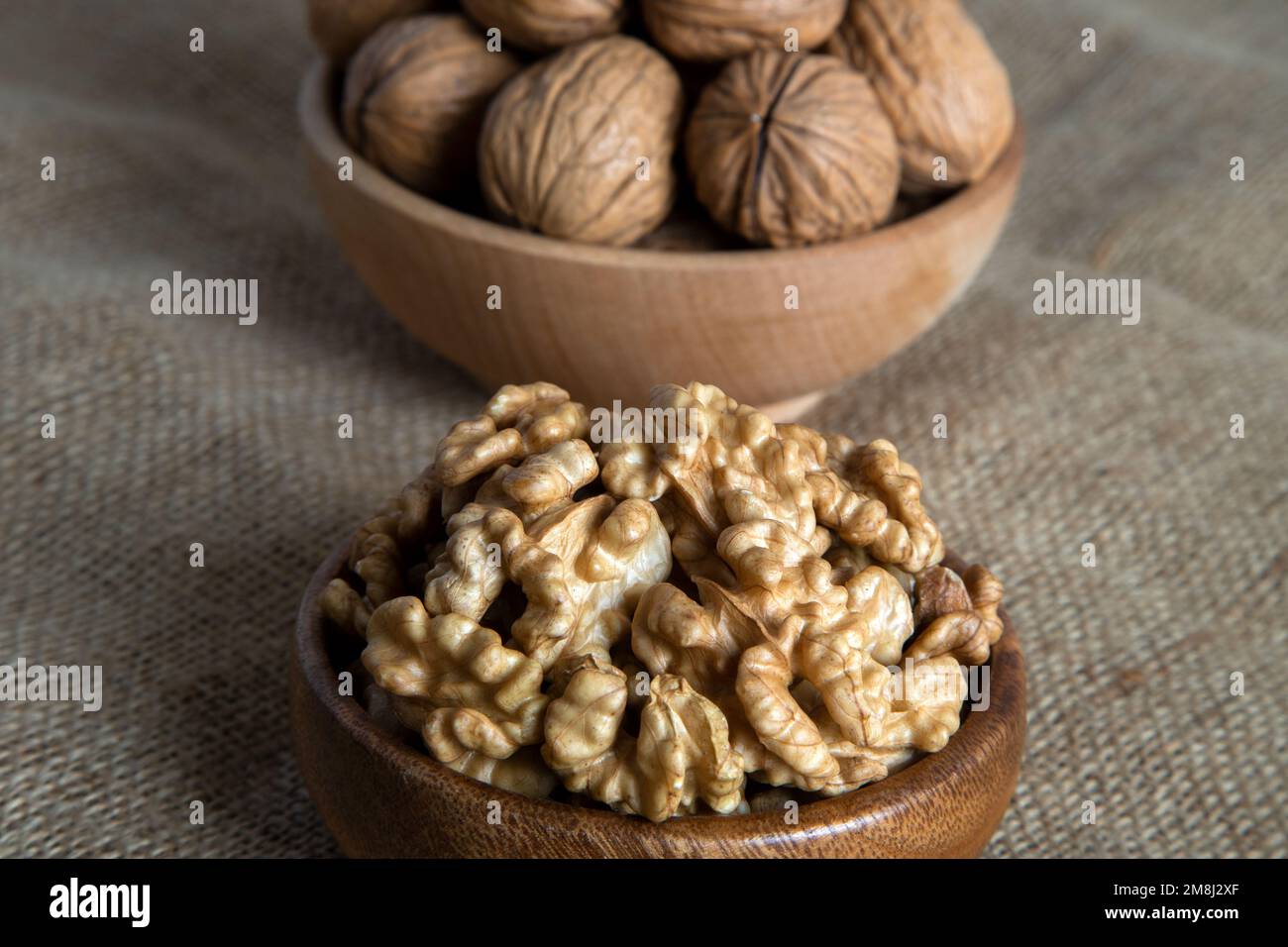 Sbucciare le noci e le noci intere sul sacco Foto Stock