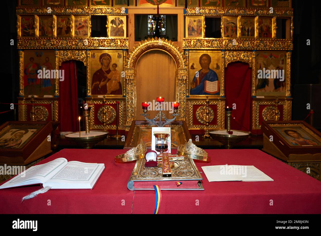 Bruxelles, Belgio -07 gennaio 2023: Tavolo per la cerimonia nuziale ortodossa con 2 corone e anelli di nozze su una bibbia e una croce in una chiesa di Bruxelles Foto Stock
