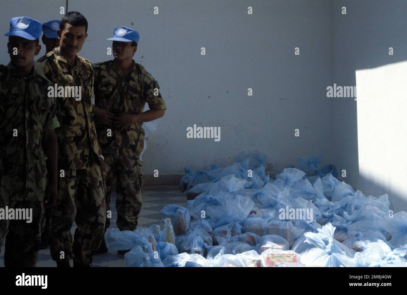 I soldati nepalesi si preparano a distribuire alimenti ai somali che vivono di fronte al loro composto. I nepalesi celebrano il compleanno del loro Re aiutando i meno fortunati. Soggetto operativo/Serie: UNOSOM II base: Mogadiscio Paese: Somalia (SOM) Foto Stock