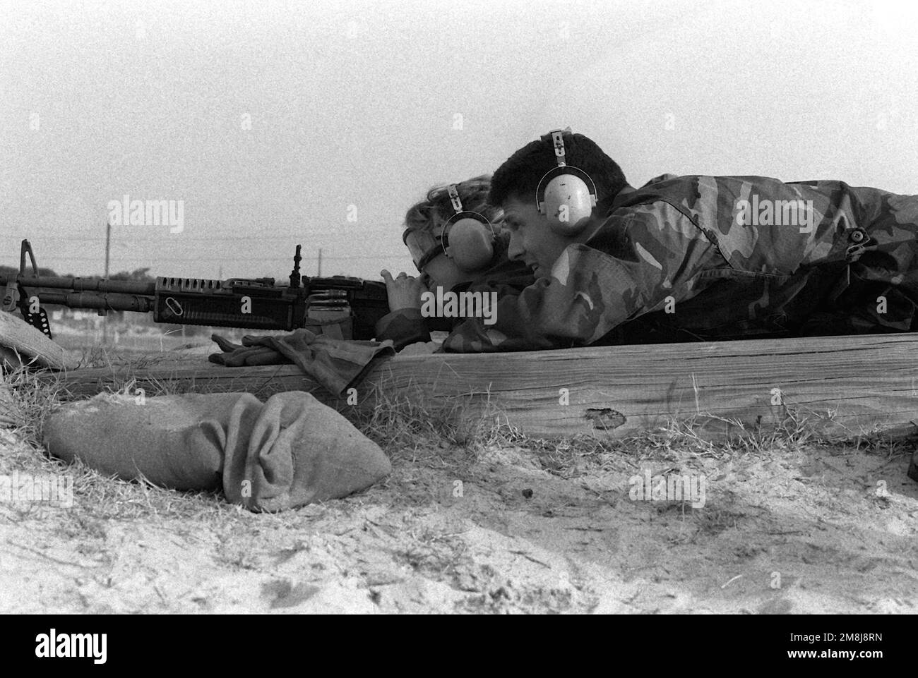 Photographers Mate First Class (PH1) Dave Hanselman, un videografo con Combat Camera Group, Atlantic, fornisce supporto al giornalista Broadcast Third Class (JO3) Wendy Hamme mentre spara la mitragliatrice M-60 dalla posizione prona. Questo supporto aggiuntivo garantisce che l'arma non salga o non si controlli. Base: Fort Eustis Stato: Virginia (VA) Nazione: Stati Uniti d'America (USA) Foto Stock