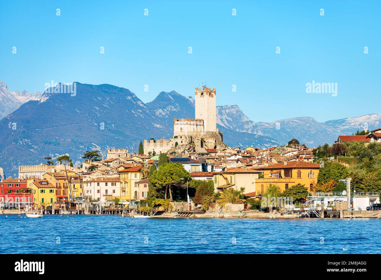 Lago di Garda (Lago di Garda) con borgo di Malcesine, castello medievale. Provincia di Verona, Italia, Veneto, Europa. Sullo sfondo la costa della Lombardia. Foto Stock