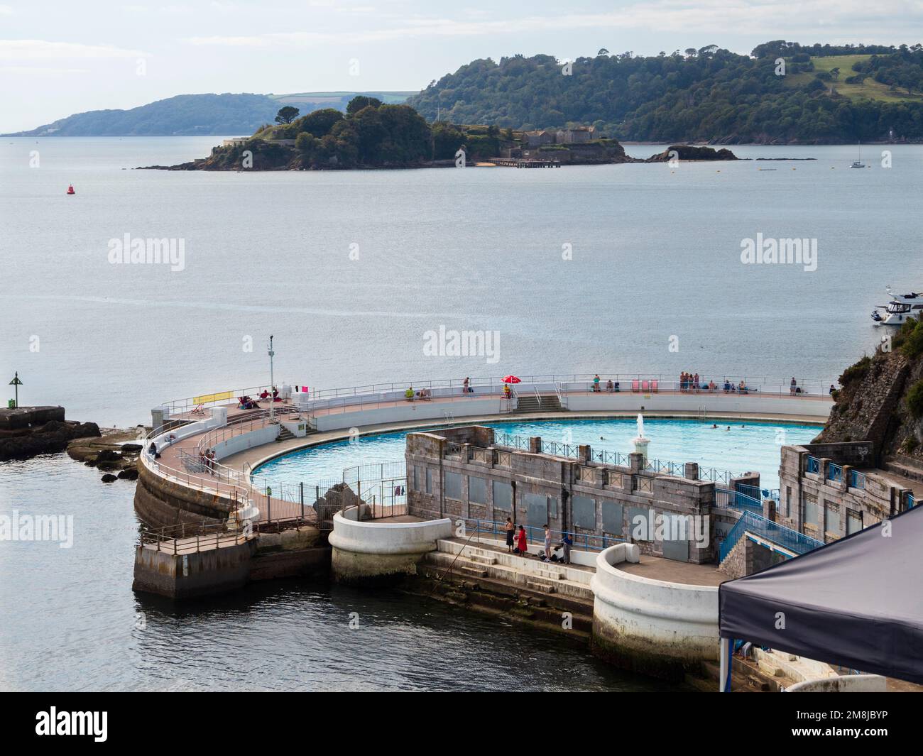 TInside Lido sul lungomare di Plymouth Hoe, Devon, Regno Unito. Drake's Island e la costa della Cornovaglia in cima. Foto Stock