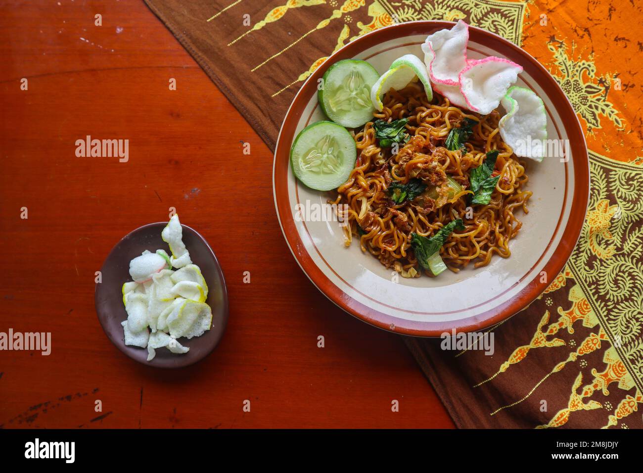 mie tek tek o spaghetti fritti fatti con tagliatelle di uovo con pollo, cavolo, verde di senape, polpette, uova strapazzate. cibo indonesiano Foto Stock