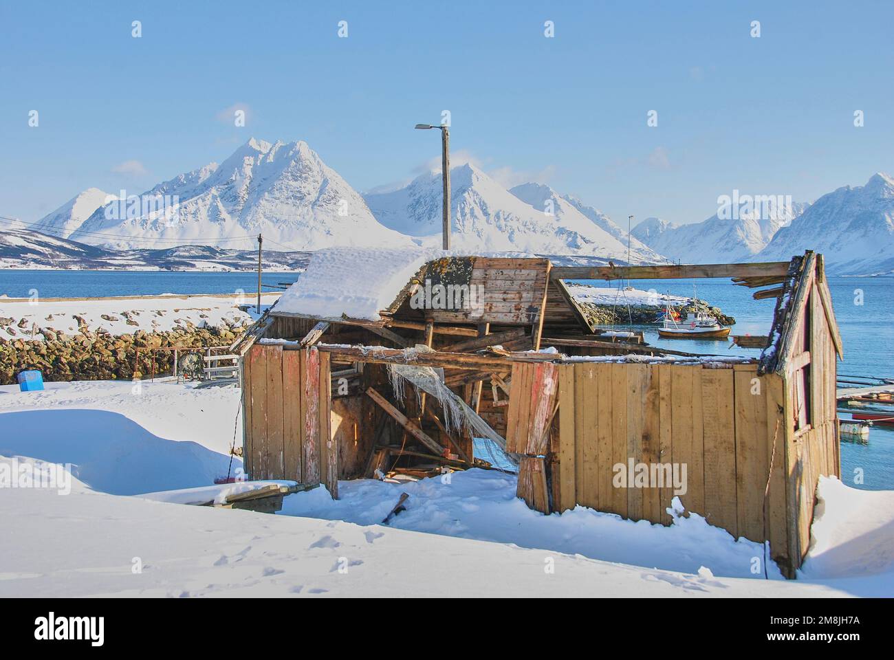 Paesaggio invernale con montagne innevate e una capanna fisher su un fiordo nella regione artica della Norvegia settentrionale vicino a Tromso Foto Stock