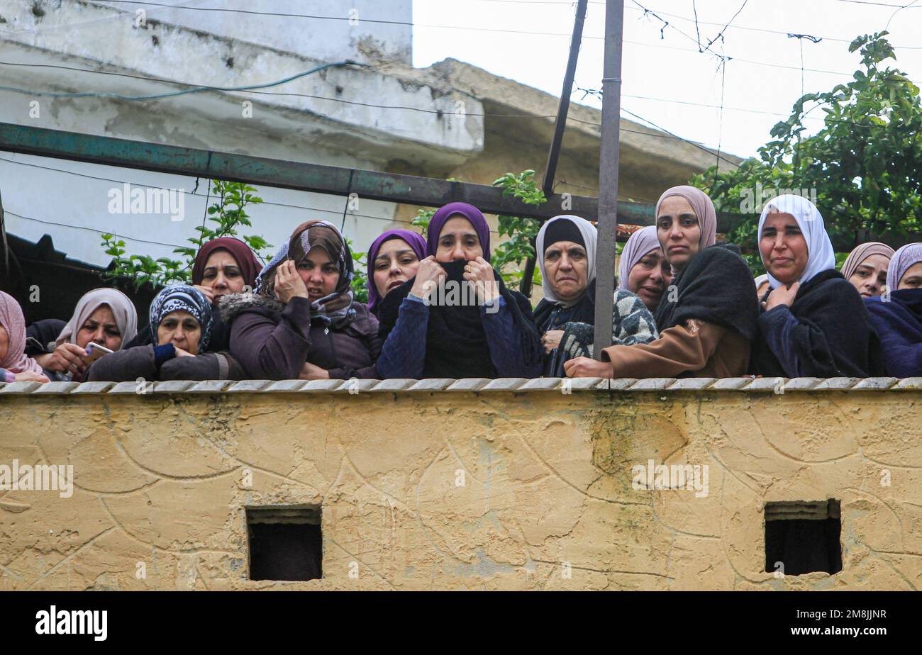 Jenin, Palestina. 14th Jan, 2023. I parenti piangono durante la cerimonia funeraria di uno dei due palestinesi che sono stati uccisi a colpi di arma da fuoco dall'esercito israeliano mentre erano stati perseguitati dopo aver aperto il fuoco su un posto militare, nella città di Jaba, vicino a Jenin, in Cisgiordania. Credit: SOPA Images Limited/Alamy Live News Foto Stock