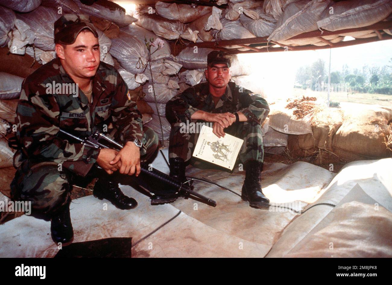 PFC. Dominic Betbeze (L) e SGT. David Curtis, (R) 3rd plotone, 325th Charlie Company, Airborne Combat Team (ABCT), Southern European Task Force (SETAF), Brigata della Fanteria, esercito degli Stati Uniti, Vicenza, Italia, Siediti in un bunker leggendo un manuale della mitragliatrice M-60. PFC. Betbeze è armato di un fucile M-16. Il bunker si trova sul tetto dell'edificio del terminal dell'aeroporto. Subject Operation/Series: RIPRISTINARE LA SPERANZA base: Kigali Paese: Ruanda (RWA) Foto Stock