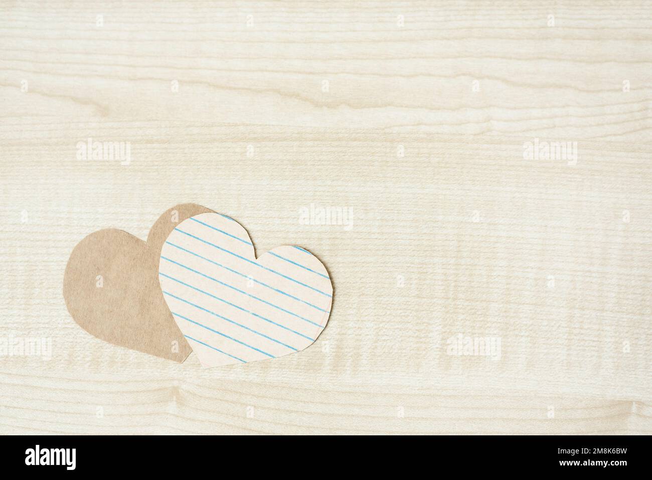 Due cuori di carta su sfondo di legno chiaro. Semplice mockup piatto Foto Stock