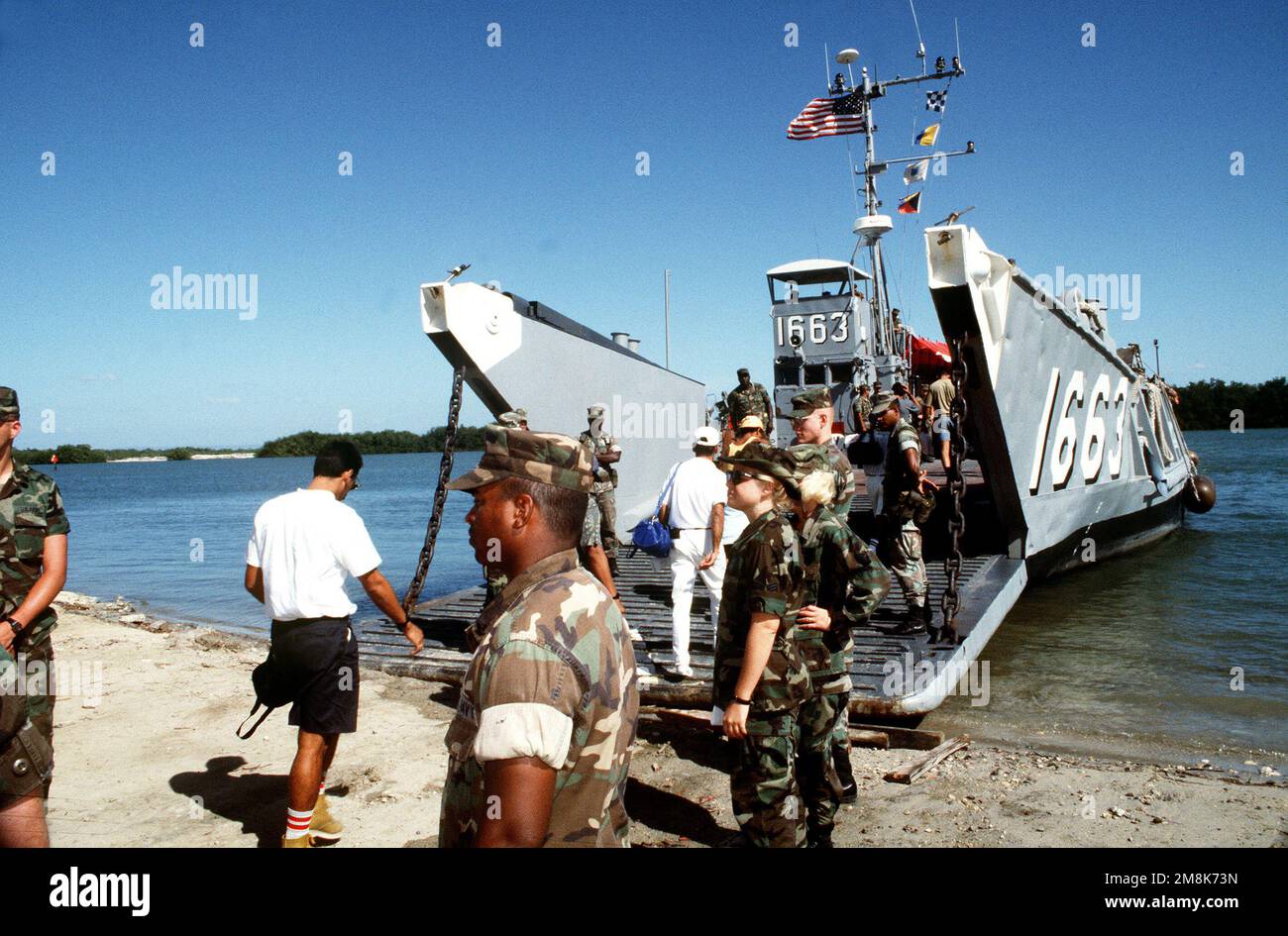 Il personale militare guarda mentre i migranti cubani che ritornano a Guantánamo Bay da Panama vengono caricati su un'imbarcazione di atterraggio (LCU-1663). L'imbarcazione di atterraggio li fercherà nei campi migranti sul lato sopravento della base. Subject Operation/Series: SEA SIGNAL base: Guantánamo Bay Paese: Cuba (CUB) Foto Stock