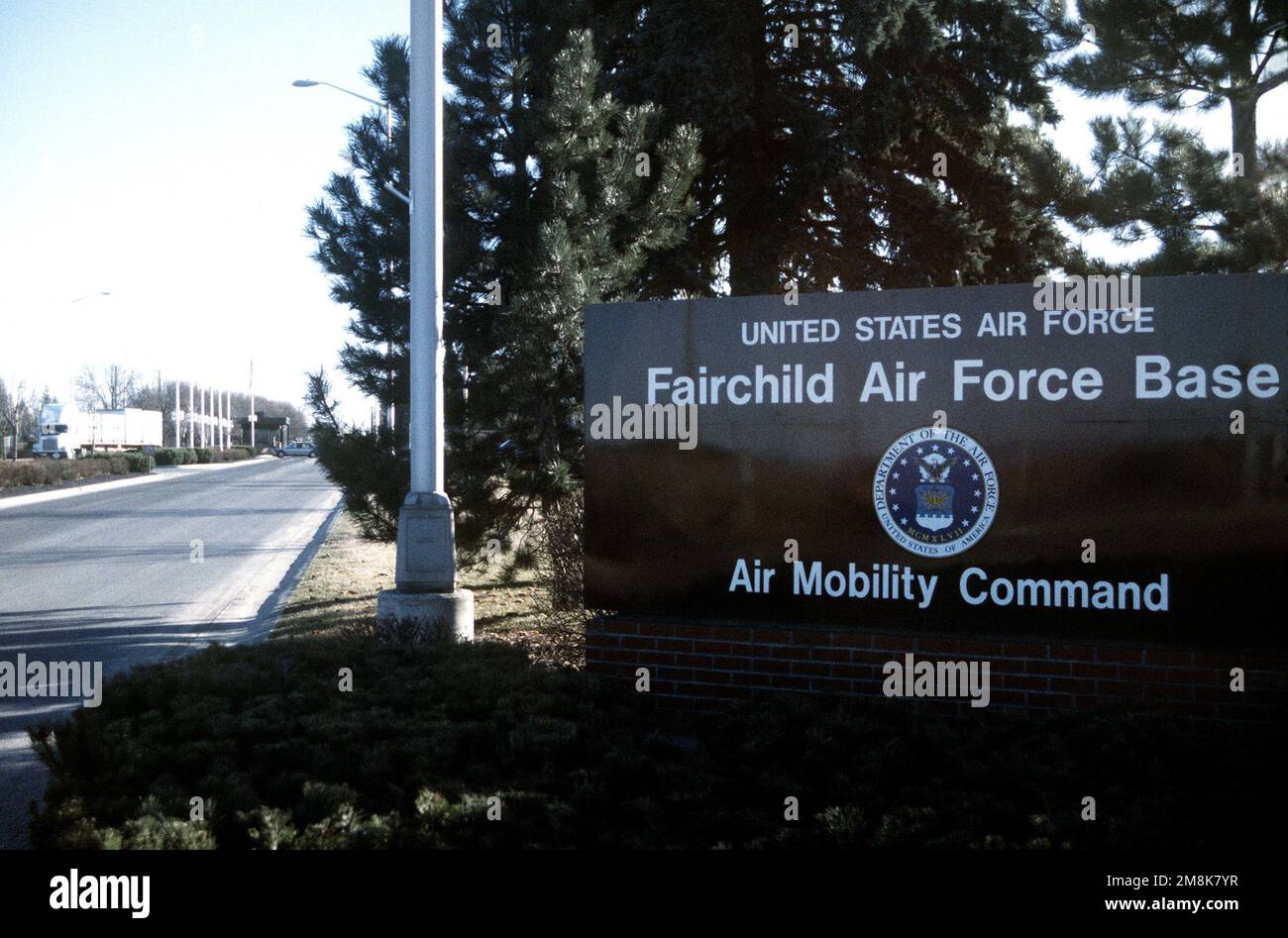 Una vista a lungo raggio del cancello principale con il cartello di base in primo piano. Base: Fairchild Air Force base Stato: Washington (WA) Paese: Stati Uniti d'America (USA) Foto Stock
