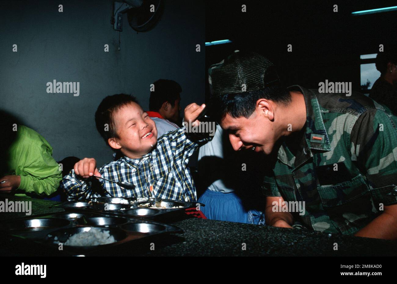 USAF secondo tenente Fernando Molina, comandante di sezione, 554th Red Horse Civil Engineering Squadron, Osan AB, Corea del Sud ha scoperto che i cappelli sono popolari con gli orfani a Song SIM Orphanage No. 90 vicino Osan AB, Corea del Sud. Dal numero di maggio 1995 DI AIRMAN Magazine 'The Bad Luck Club'. Paese: Repubblica di Corea (KOR) Foto Stock