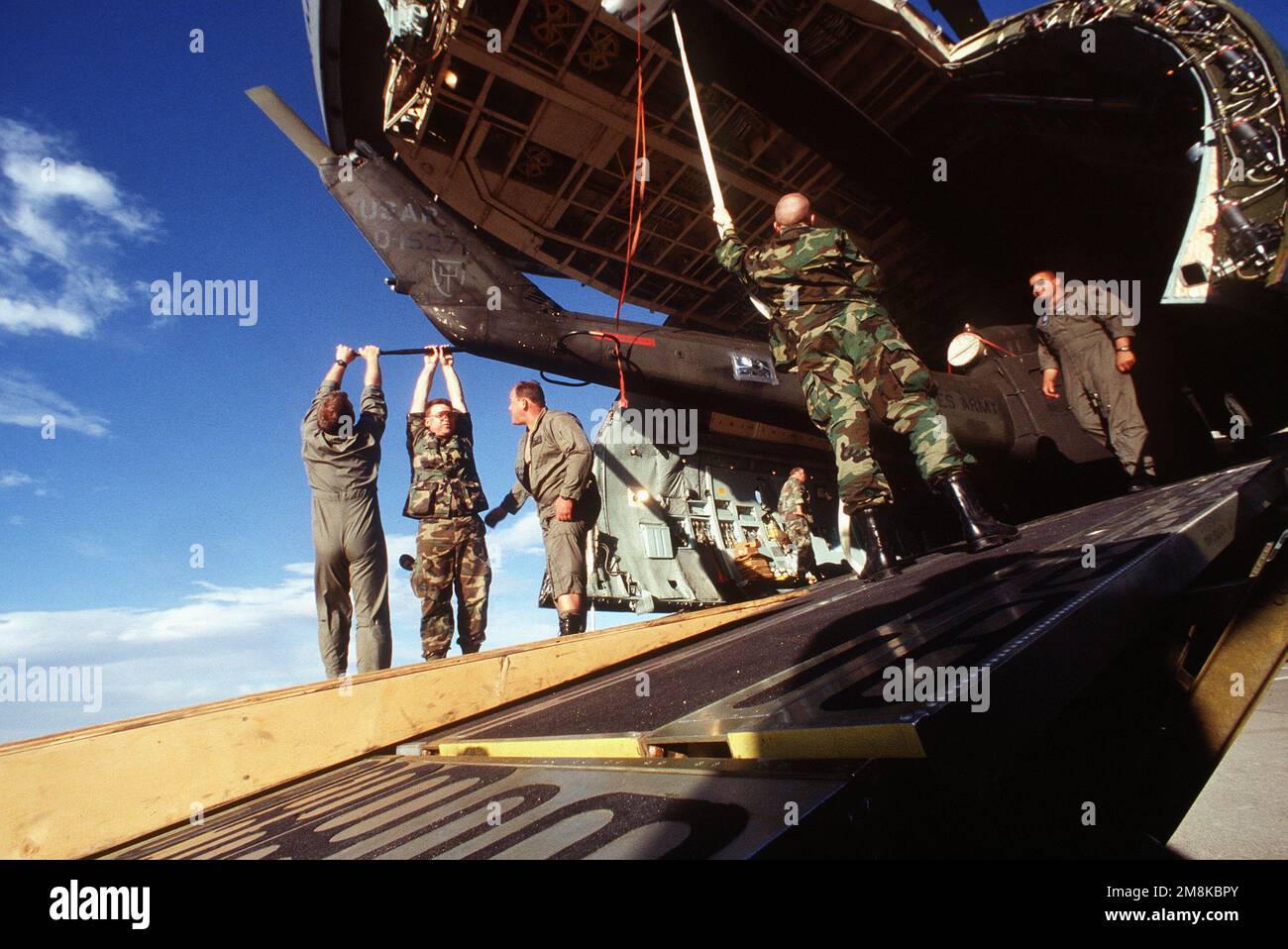 I membri di Alpha Company, 2/228th Battaglione Aviazione 'Guerrieri Winged', base aerea navale Willow Grove, Pennsylvania, e i loadmaster C-5 di 349th Air Mobility Wing, 60th Air Mobility Wing, scaricano uno dei numerosi UH-1-H 'Iroquois' dalla rampa di carico anteriore della 'Città di Vallejo'. Soggetto operativo/Serie: ROVING SANDS '95 base: Biggs Army Air Field, El Paso Stato: Texas (TX) Paese: Stati Uniti d'America (USA) Foto Stock