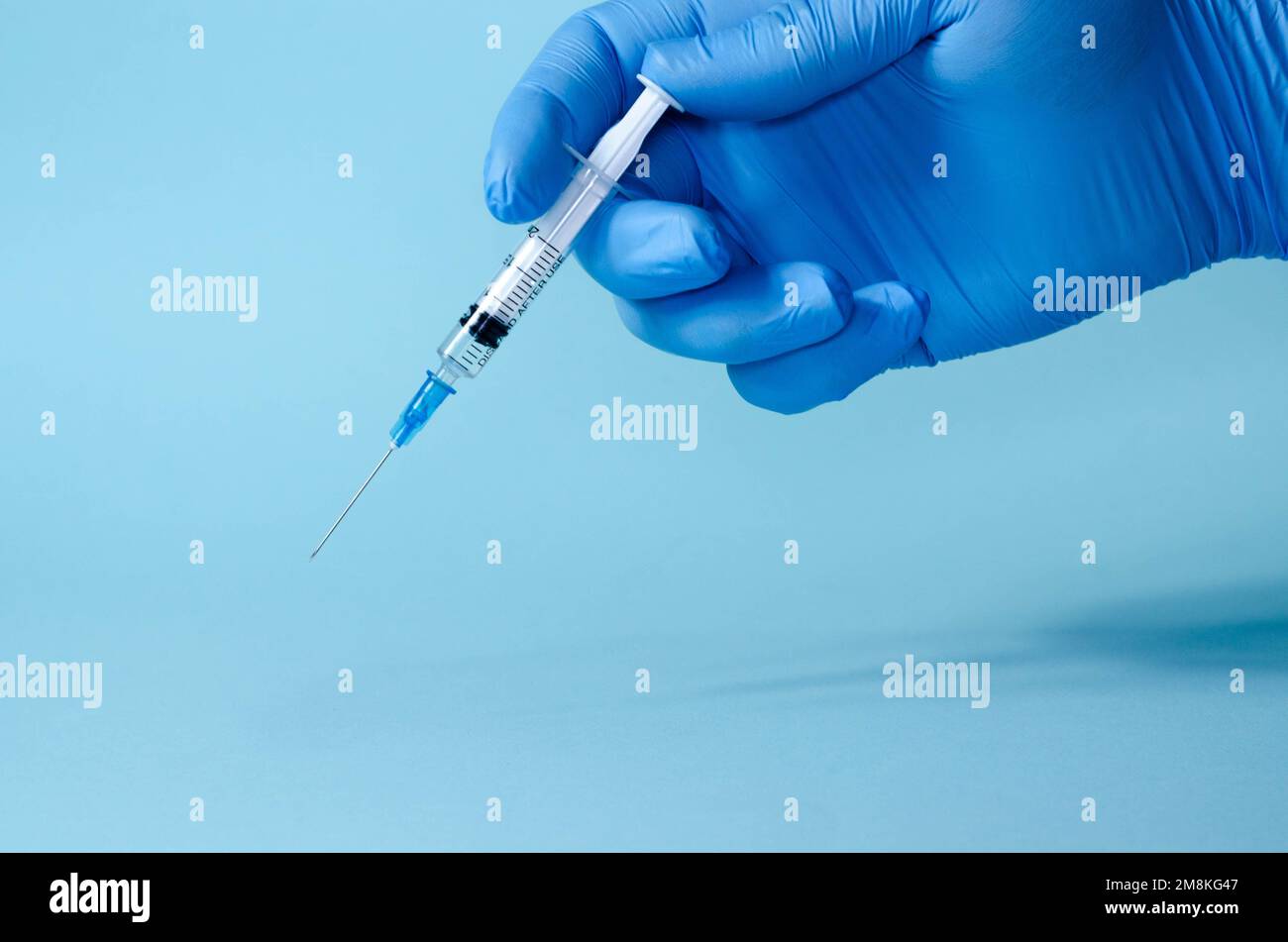 Medico in guanti di lattice blu con siringa, primo piano. Effettuare un'iniezione di vaccino. Contagio, incubazione, dices lettera su siringa. Foto Stock