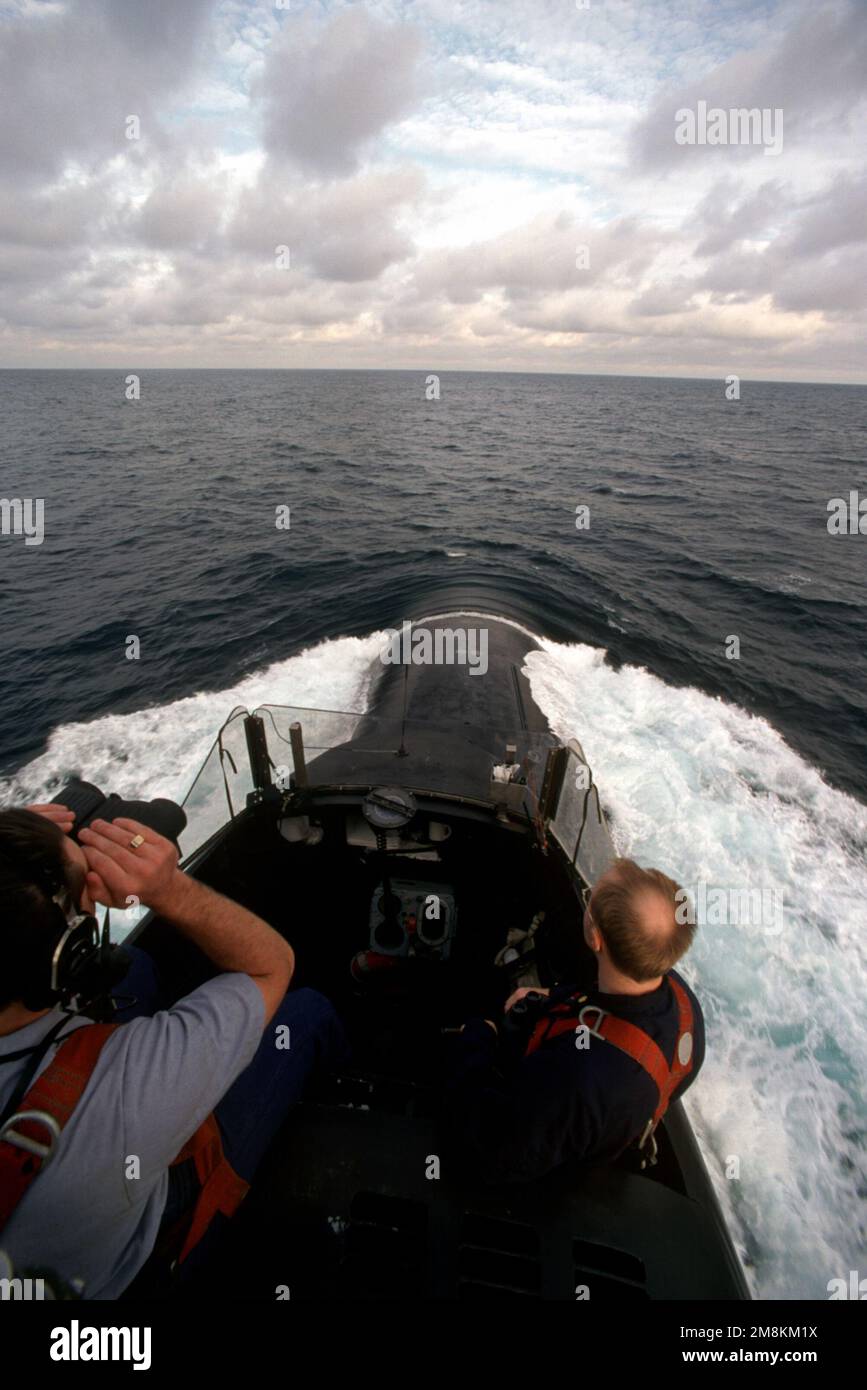 Una vista che guarda avanti dalla cima della vela fairweather del sottomarino missilistico balistico nucleare USS PENNSYLVANIA (SSBN-735) mentre la nave naviga al largo della costa degli Stati Uniti. Un osservatorio utilizza binocoli per scansionare l'orizzonte. Paese: Sconosciuto Foto Stock