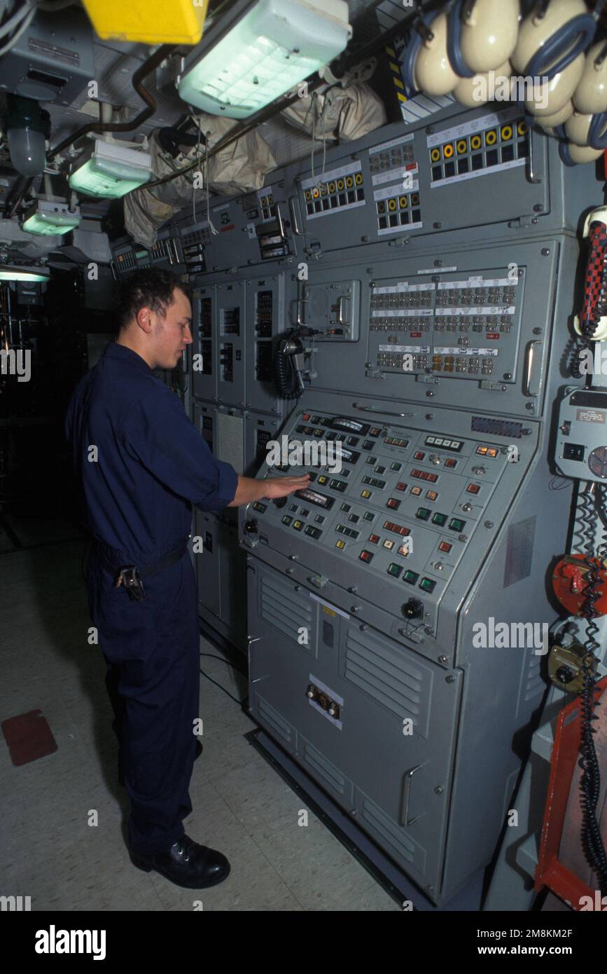 Un siledomano sta controllando la console di controllo antincendio nella sala siluro del sottomarino missile balistico nucleare USS PENNSYLVANIA (SSBN-735). Paese: Sconosciuto Foto Stock