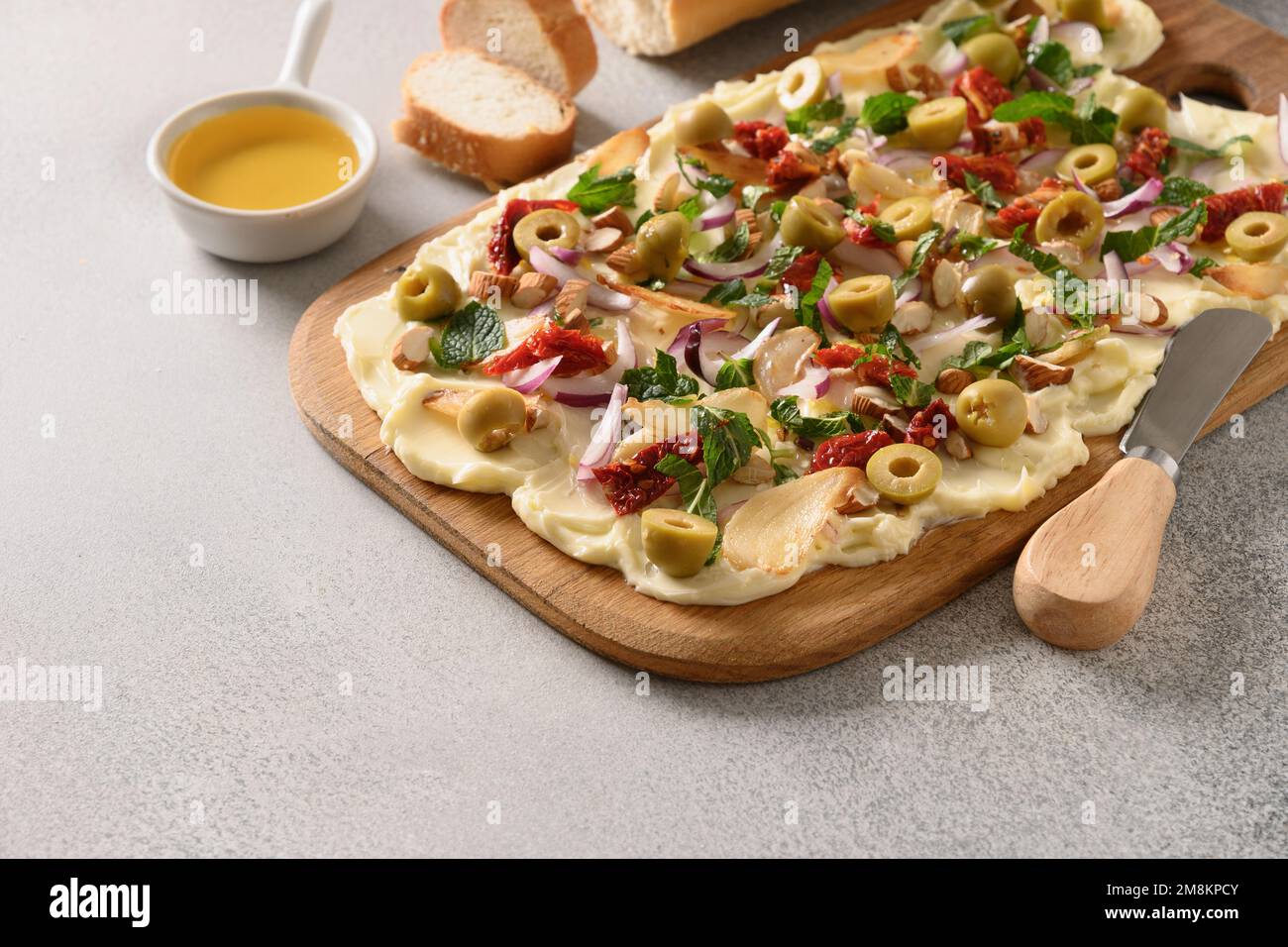 Butterboard alla moda fatta in casa con cipolla, aglio, arancia, erbe aromatiche, baguette croccanti e toast su sfondo grigio. Primo piano. Foto Stock