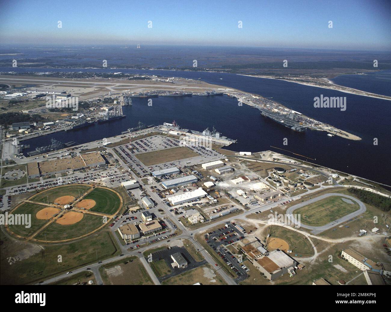 Vista verso nord-ovest che mostra il bacino della nave e la stazione dell'aria. La portaerei della Riserva Navale USS JOHN F. KENNEDY (CV-67) è legata al molo della portaerei. Base: Naval Station, Mayport Stato: Florida (FL) Paese: Stati Uniti d'America (USA) Foto Stock