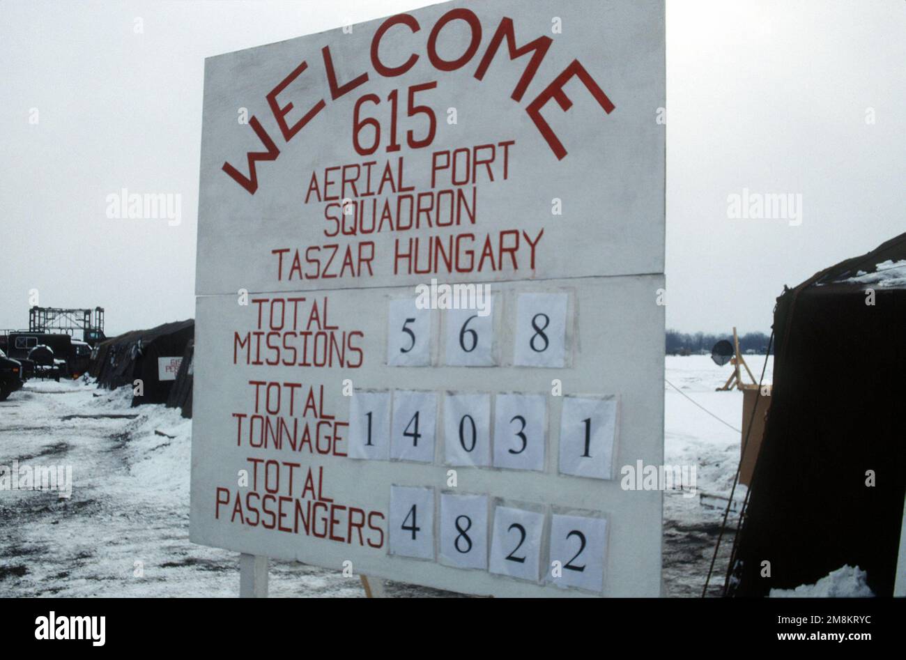 Un cartello di benvenuto alla base indica il numero totale di missioni, tonnellaggio e passeggeri gestiti dallo Squadrone del Porto aereo 615th. Base: Taszar Air base Paese: Ungheria (HUN) Foto Stock
