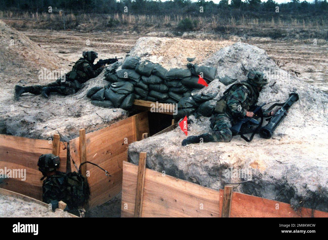 I soldati si coprono dietro i bunker e nelle trincee durante l'allenamento della compagnia STX Lane (Breach). I soldati sono armati di fucili M-16 e di un'arma multivalente d'assalto lanciata dalla spalla (SMAW). Soggetto operativo/Serie: SITUATIONAL TRAINING ESERCITAZIONE base: Fort Stewart Stato: Georgia (GA) Paese: Stati Uniti d'America (USA) Foto Stock