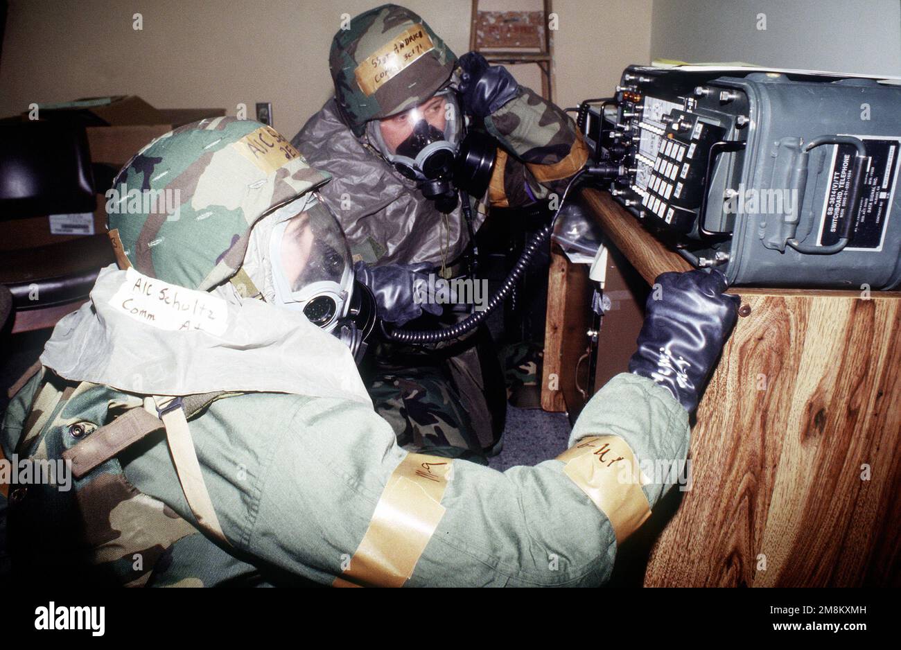 Indossando le maschere e i guanti da guerra chimica, SSGT John Andrich (sfondo) e AIRMAN 1st Class Brent Schultz, entrambi provenienti dall'elemento MIC (Mobile Initial Communication) dello Squadron 341st, tornano al loro lavoro di monitoraggio del pannello di controllo tattico SB3614 durante le condizioni di "allarme nero". Il negozio MIC e altre unità di supporto della 341st Missile Wing partecipano all'esercizio settimanale del 43rd Air Refueling Group che include un breve intervento di messa in servizio e come operare in un ambiente di combattimento. L'esercizio si sta svolgendo in preparazione di una prossima lettura operativa Foto Stock
