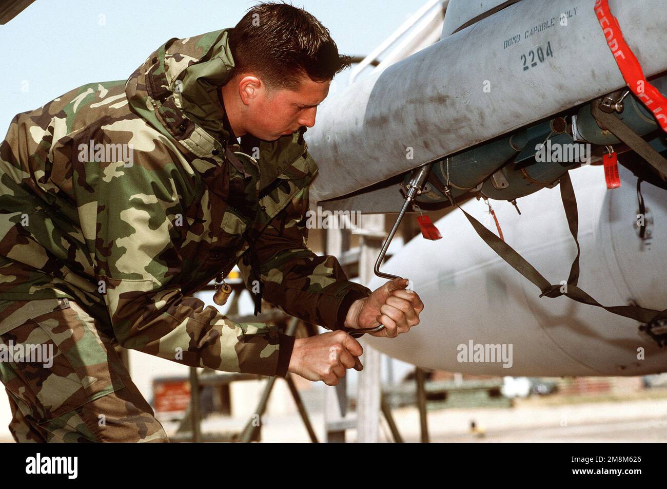 AIRMAN 1st Class Clifton Gregory carica con attenzione bombe GPU-25 blu. Exact Date Shot Unknown pubblicato su AIRMAN Magazine Agosto 1996. Base: KUNSAN Air base Nazione: Repubblica di Corea (KOR) Foto Stock