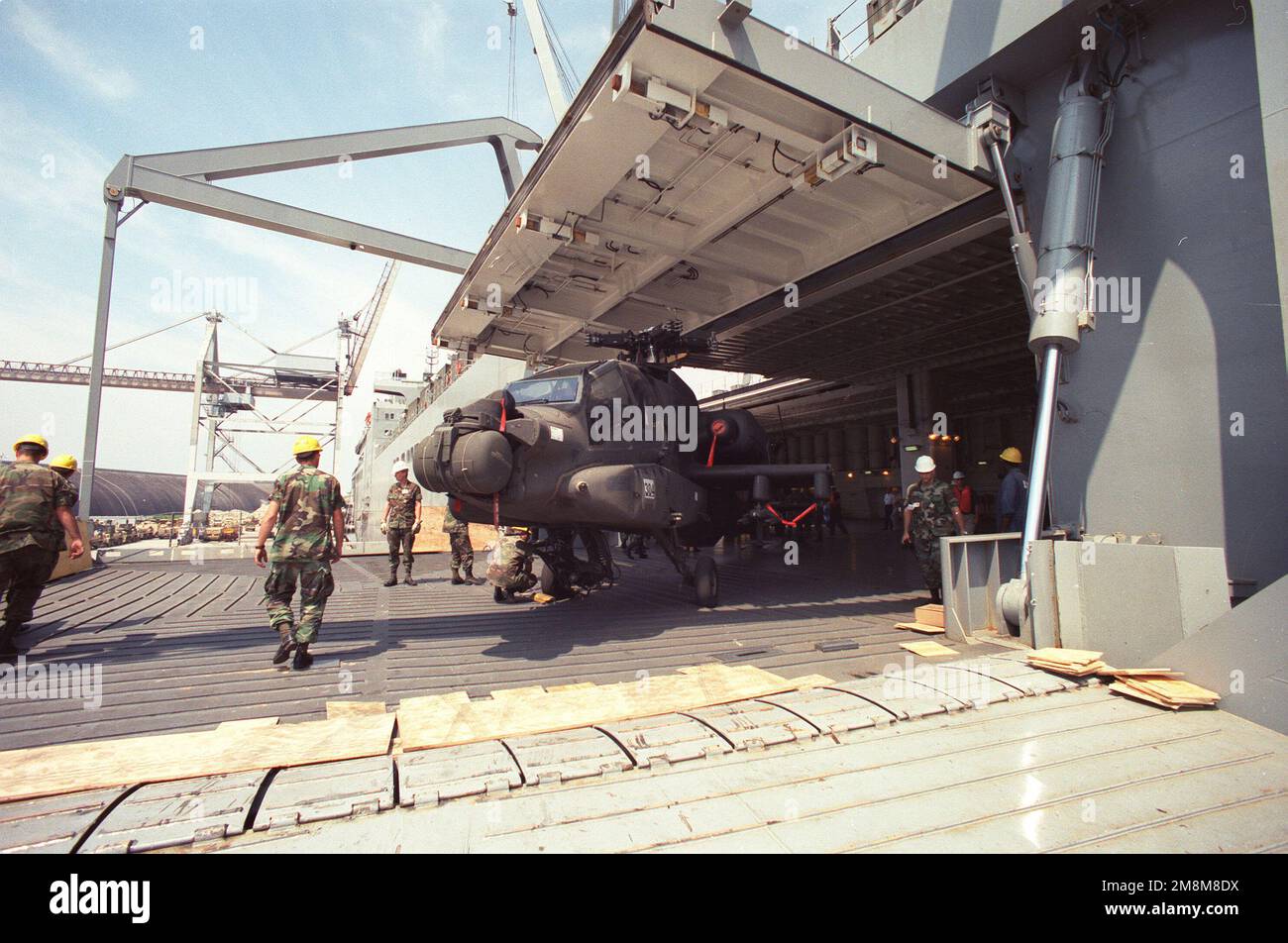 Un elicottero AH-64 Apache con le pale del rotore rimosse viene messo in scena per essere schierato a bordo della USNS SHUGHART (T-AKR-295) per la 3D° divisione fanteria. Oggetto operazione/Serie: SEALIFT ESERCITAZIONE DI PREPARAZIONE ALL'IMPLEMENTAZIONE DI EMERGENZA Paese: Sconosciuto Foto Stock