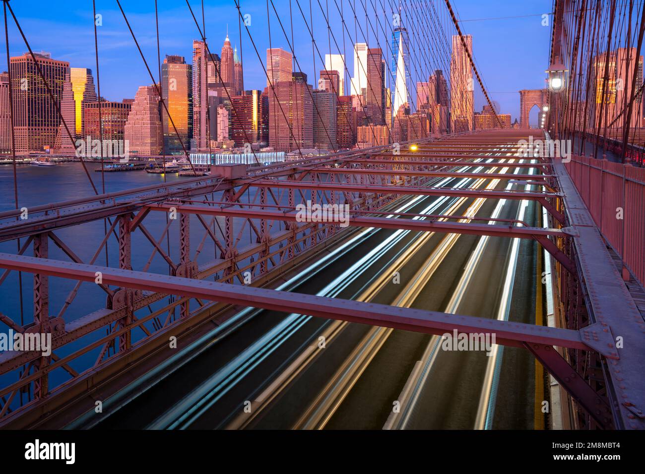 Fari per auto sul ponte di Brooklyn all'alba. Manhattan, New York, Stati Uniti Foto Stock
