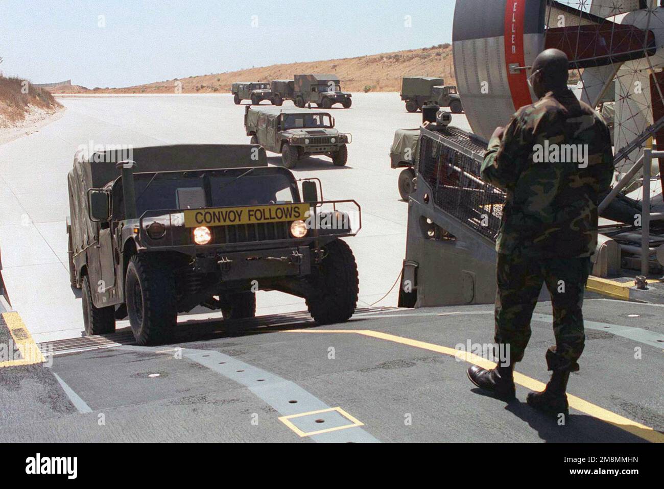 Un direttore dell'imbarcazione dell'UNITÀ 5 DELL'IMBARCAZIONE D'ASSALTO dirige il carico dei veicoli HMMMWV (High-Mobility Multipurpose Wheel Vehicles) su un'imbarcazione LCAC (Landing Craft Air Scuscino) a sostegno del KERNEL BLITZ 97. La LCAC galleggia su una cusion di aria contenuta da una gonna di gomma che permette la capacità di transitare dall'acqua alla terra. Con un carico utile di sessanta tonnellate, l'imbarcazione LCAC è in grado di sostenere fino a 50 kt/91 khp per un raggio d'azione fino a 328nm/607 km Soggetto operativo/Serie: KERNEL BLITZ 97 base: Marine Corps base Camp Pendleton Stato: California (CA) Paese: Stati Uniti d'America (USA) Foto Stock