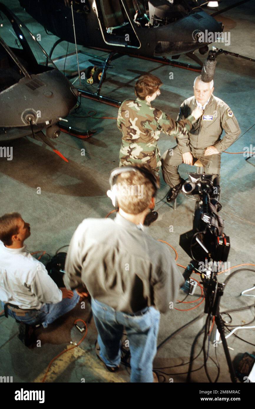 BGEN Don Streater, comandante dell'operazione di recupero A-10, siede come tecnici del suono e della macchina fotografica del programma della buona mattina America di ABC preparano per un'intervista in tensione nell'hangar del luogo di addestramento dell'alta altitudine della Guardia nazionale dell'esercito del Colorado. Base: Gold Dust Peak Stato: Colorado (CO) Paese: Stati Uniti d'America (USA) Foto Stock