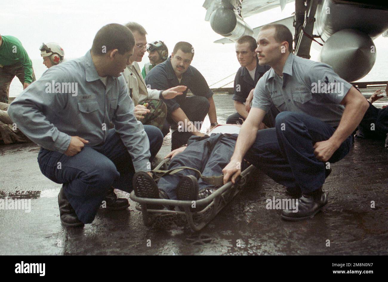 Gli equipaggi della Marina STATUNITENSE aiutano a trasportare un compagno di nave ferito durante un'esercitazione di addestramento di massa sul ponte di volo della portaerei convenzionale USS INDEPENDENCE (CV 62). L’INDIPENDENZA viene distribuita nel Golfo Persico per imporre le sanzioni delle Nazioni Unite contro l’Iraq. Operazione orologio SOUTHRN, 21 febbraio 1998. Operazione/Serie oggetto: SOUTHERN WATCH base: USS Independence (CV 62) Foto Stock