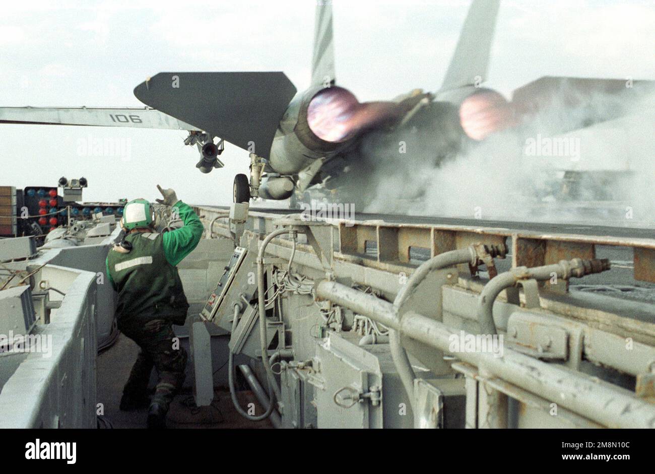 US Navy Aviation Boatswain Mate (Launch and Recovery Equipment Operator) 3rd Classe (Ab3) Joshua Schwandt segnala un chiaro lancio di un F-14 Tomcat dalla catapulta del porto delle navi. A bordo della portaerei convenzionale USS INDEPENDENCE (CV 62), che viene schierata in avanti nel Golfo Persico per imporre sanzioni ONU contro l'Iraq durante l'operazione SOUTHERN WATCH, 22 febbraio 1998. Operazione/Serie oggetto: SOUTHERN WATCH base: USS Independence (CV 62) Foto Stock