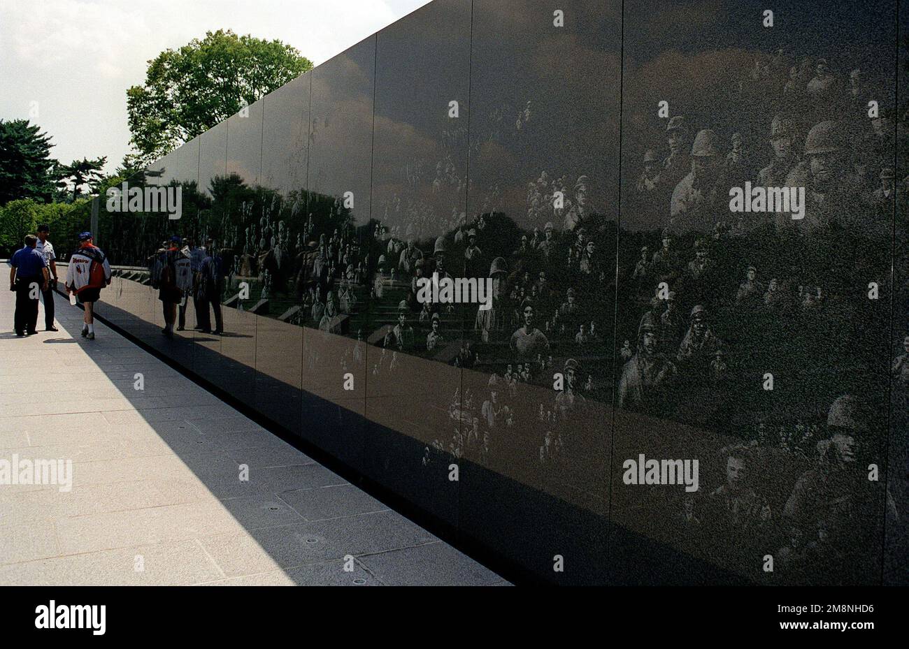 La parete di granito nero, altamente lucidata, con le facce di veterani incise riflette le facce dei visitatori del Korean War Veterans Memorial situato nel National Mall vicino alla piscina riflettente. Data esatta dell'acquisizione sconosciuta. Base: Washington Stato: District of Columbia (DC) Nazione: Stati Uniti d'America (USA) Foto Stock