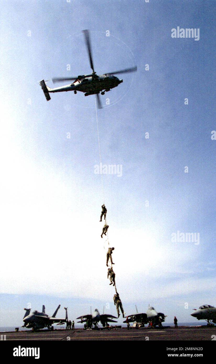 Un elicottero SH-60 'Seahawk' dell'elicottero anti-sottomarino Squadron THREE (HS-3) solleva una serie di esplosivi tecnici di smaltimento delle Ordnance (EOD) durante un addestramento speciale di inserimento ed estrazione (SPIE) a bordo della USS THEODORE ROOSEVELT (CVN 71). ROOSEVELT e la sua ala aerea imbarcata partecipano a missioni di sciopero contro l'ex Jugoslavia a sostegno dell'operazione NATO Allied Force. Oggetto operazione/Serie: FORZE ALLEATE Paese: Mare Adriatico Foto Stock