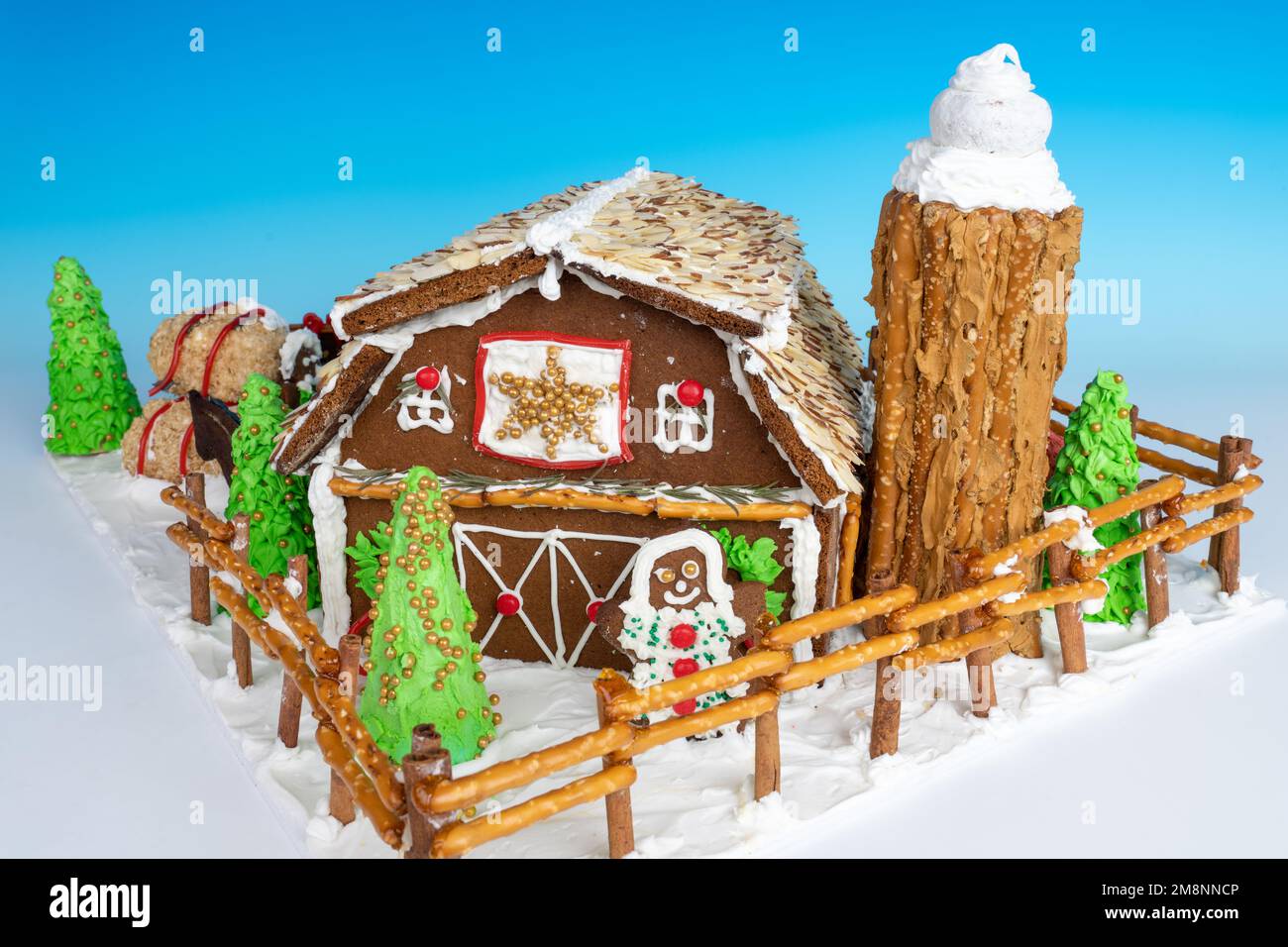 Retro di un granaio di pan di zenzero fatto in casa con silo e ragazza di pan di zenzero, circondato da una recinzione, il tutto fatto di materiali completamente commestibili. Foto Stock