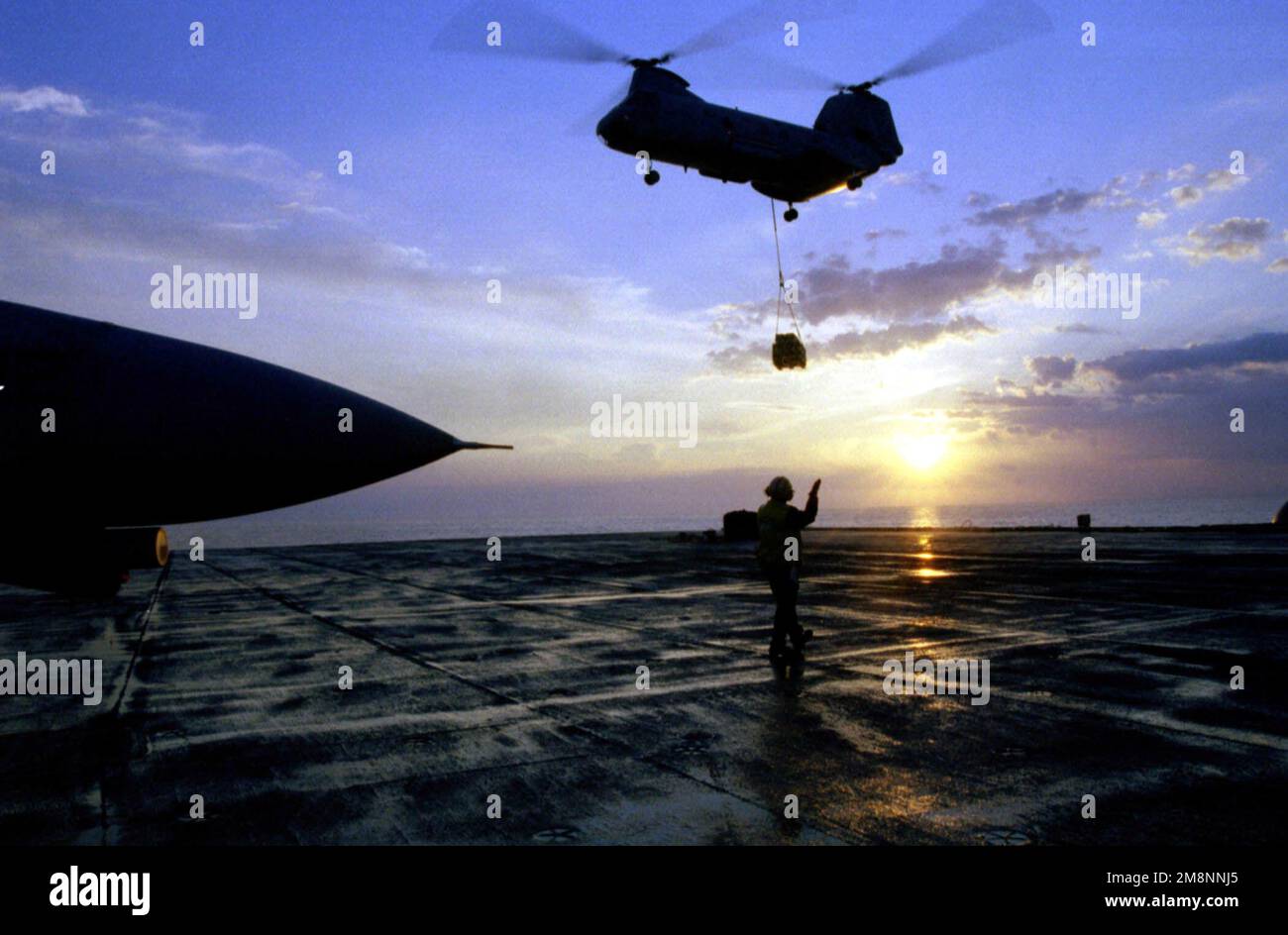 Quando il sole sorge, un elicottero CH-46 'Sea Knight' porta un altro carico di forniture da USS Arctic (AOE 8) (non mostrato) durante le operazioni di rifornimento verticale (VERT REP). ROOSEVELT e la sua ala aerea imbarcata partecipano a missioni di sciopero contro l'ex Jugoslavia a sostegno dell'operazione NATO Allied Force. Oggetto operazione/Serie: NATO Paese: Mare Adriatico Foto Stock