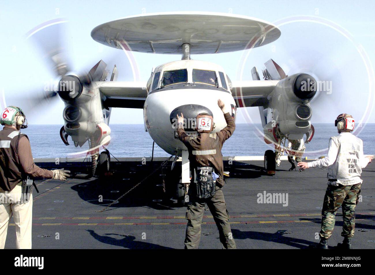 Un membro dell'equipaggio della Carrier Airborne Early Warning Squadron One Two Four (VAW-124) segnala al pilota in una e-2C 'Hawkeye' a bordo della USS THEODORE ROOSEVELT (CVN 71), mentre gira i puntelli sul ponte di volo. Questa missione è diretta a sostegno dell'operazione Allied Force. Oggetto operazione/Serie: FORZE ALLEATE Paese: Mare Adriatico Foto Stock