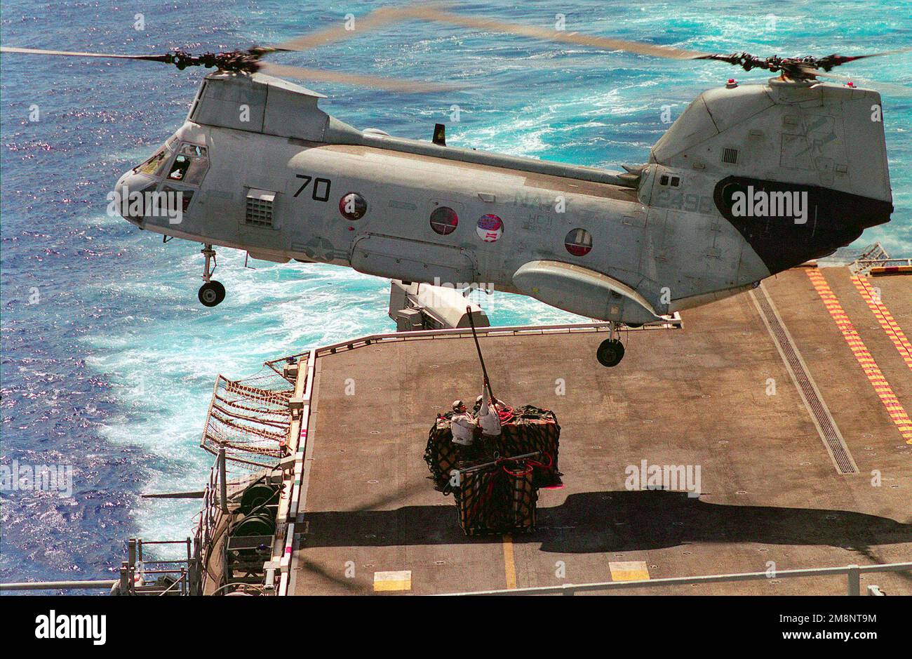 Due Marines di Combat Cargo, stazionati a bordo della nave da assalto anfibio USS PELELIU (LHA 5), tengono un gancio di carico per essere collegati a un elicottero di cavaliere di mare CH 46D da Helicopter Combat Support Squadron 11 (HC 11). Stato: Hawaii (HI) Paese: Stati Uniti d'America (USA) Foto Stock