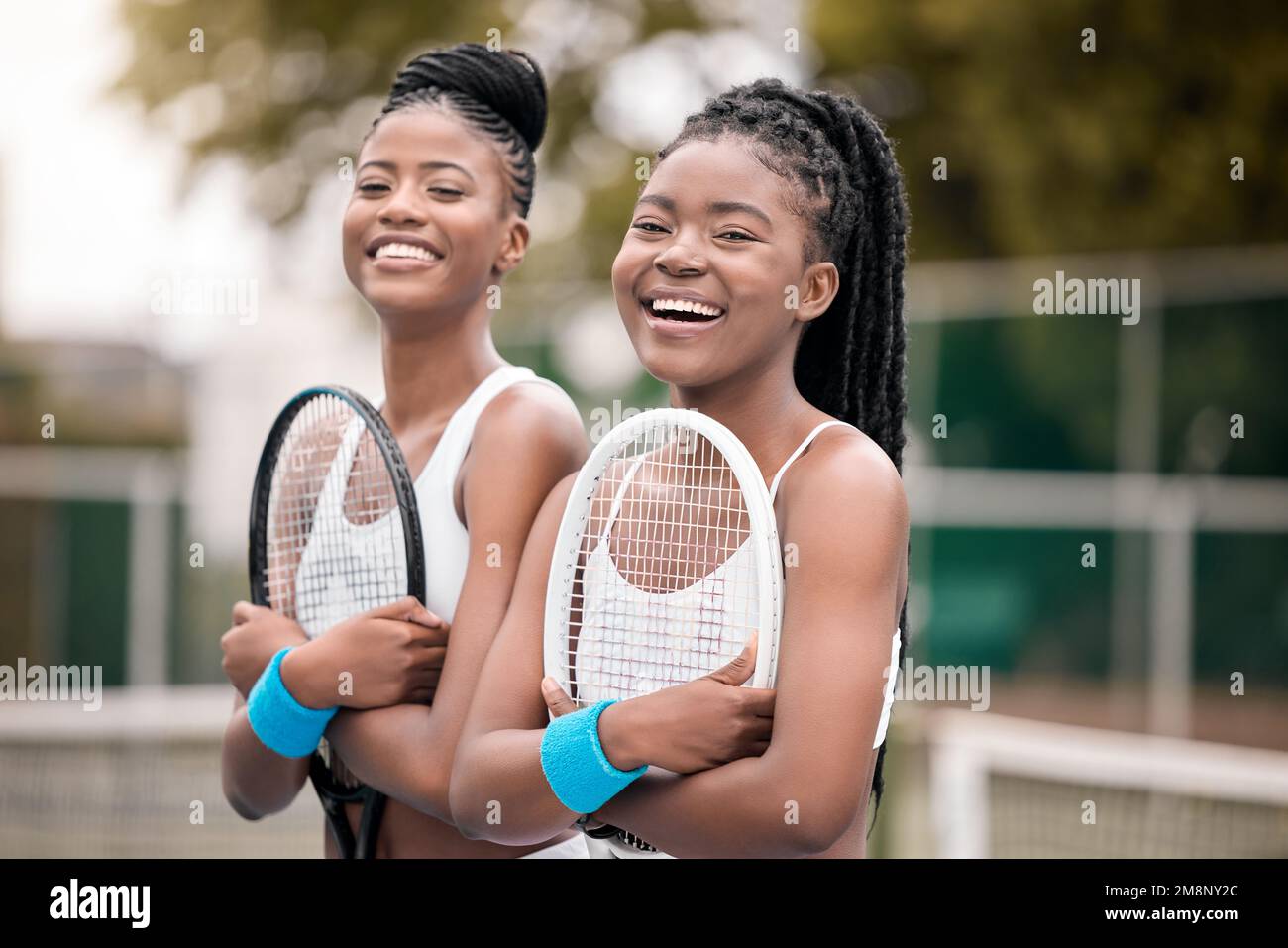 Ritratto di allegri tennisti con racchette. Giovani amici pronti per la pratica del tennis sul campo. I giocatori di tennis afroamericani ridono Foto Stock
