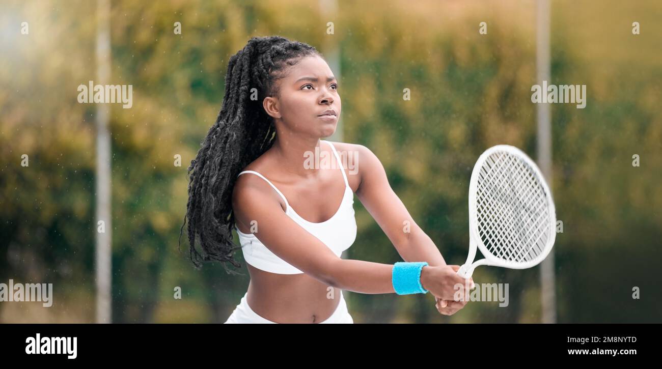 Giocatore di tennis concentrato in attesa durante una partita. Giovane donna che tiene la racchetta da tennis durante una partita. tennista professionista in attesa di colpire una palla Foto Stock