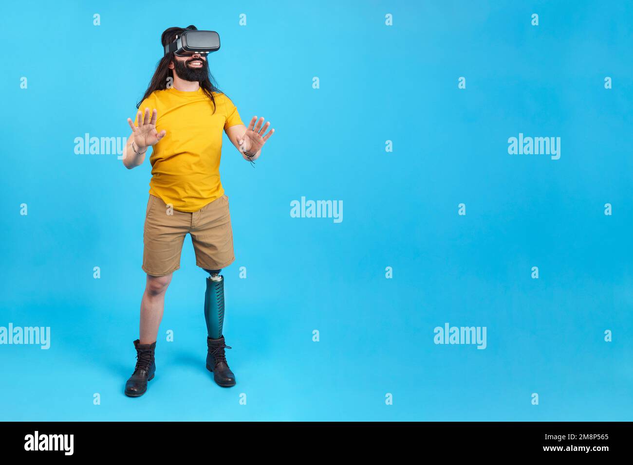 Uomo con gamba protesica gesturante mentre si usa un occhiale virtuale Foto Stock