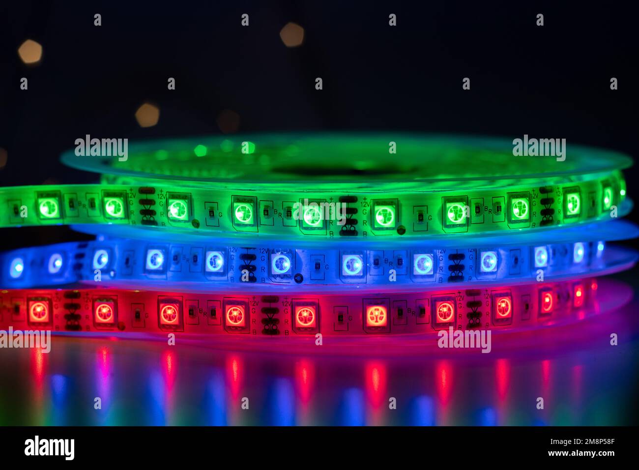 Bobina con rotolo di illuminazione LED a striscia luminosa posta sul tavolo, colore verde, rosso e blu Foto Stock