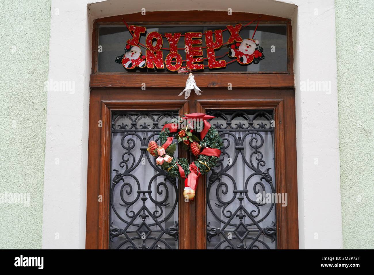 Porta di legno di una casa in Francia con decorazione natalizia e un'iscrizione in lingua francese che dice Buon Natale. Foto Stock