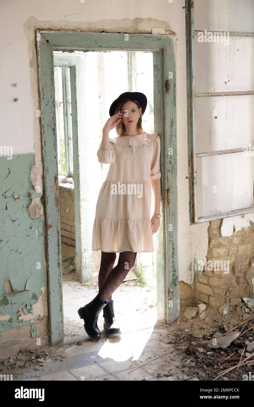 Serie di foto di modello femminile in abito beige nel abbandonato edificio in rovina Foto Stock
