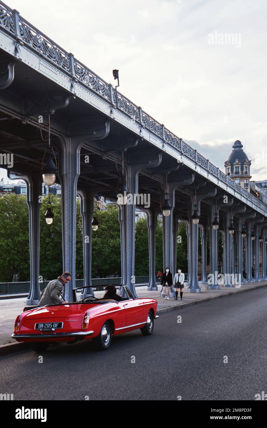 Parigi, Francia - Maggio, 2022: Un'auto sportiva rossa con lunghe colonne d'acciaio del Viadotto Passy situato al Pont de Bir Hakeim Bridge Foto Stock