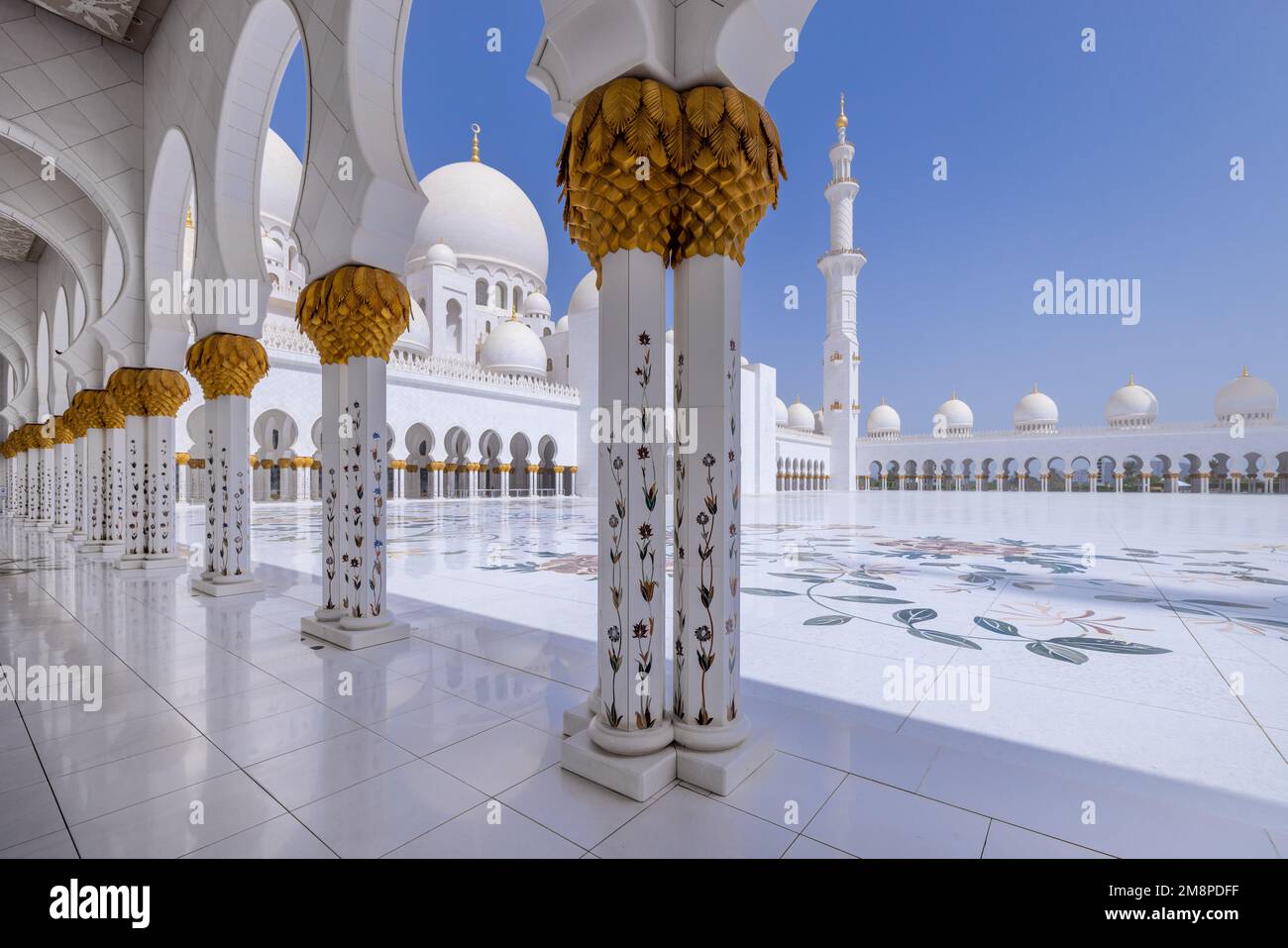 Colonnato in marmo bianco che conduce al cortile principale della grande moschea dello sceicco Zayed ad Abu Dhabi Foto Stock