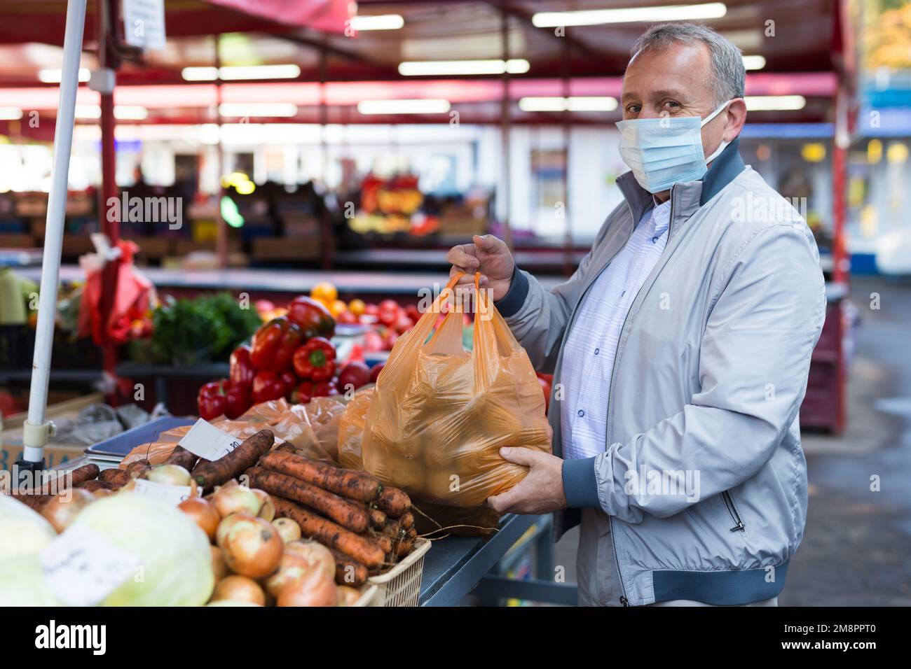 Uomo medio invecchiato in maschera di acquisto di patate Foto Stock