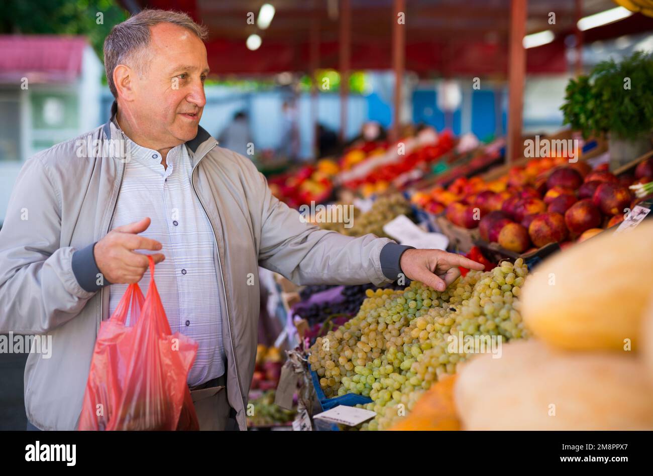 Uomo di mezza età che acquista frutti Foto Stock