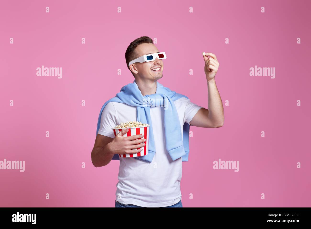 Giovane uomo caucasico in 3D bicchieri mangiare popcorn Foto Stock