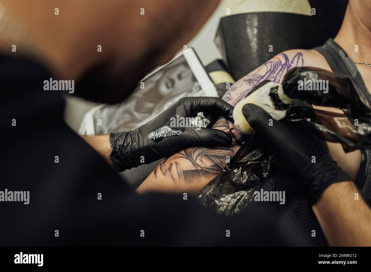 Primo piano del processo di creazione di Tattoo Art, l'artista disegna sulla pelle dei clienti Foto Stock