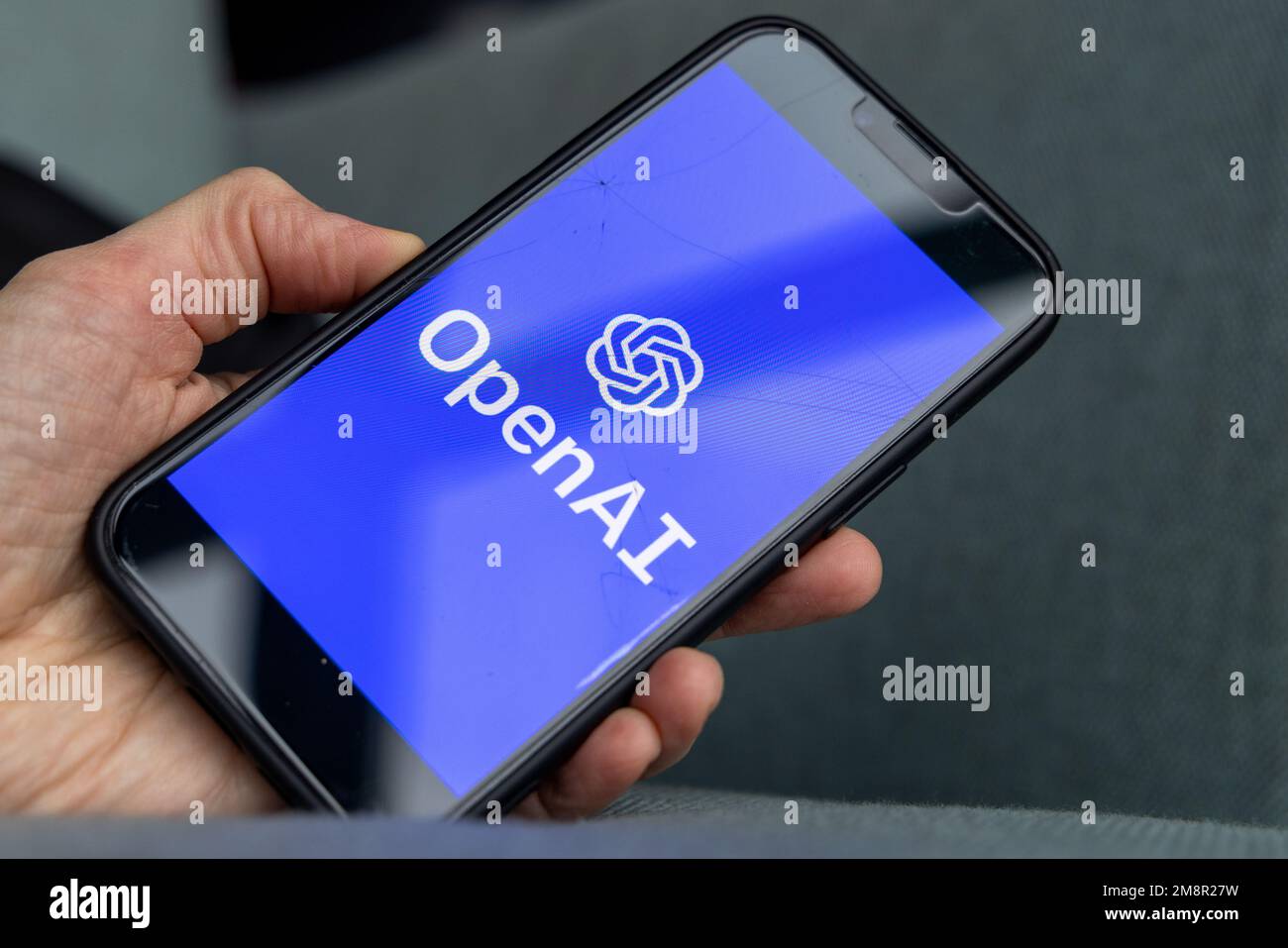 Mano da donna che tiene un iPhone con il logo OpenAI. ChatGPT e Chat ...